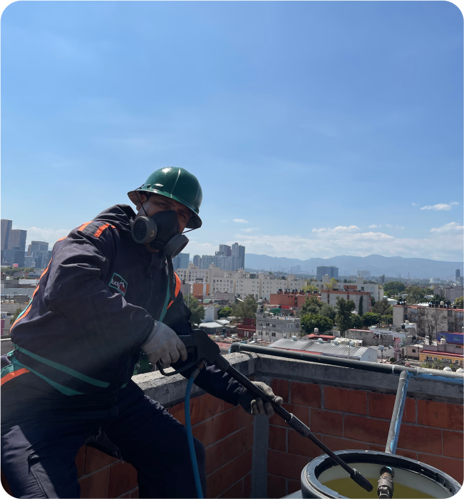 Operador enjuaga un tinaco durante el lavado de cisternas y tinacos en Álvaro Obregón