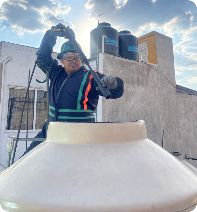 Operador enjuaga un tinaco durante el lavado de cisternas y tinacos en Naucalpan