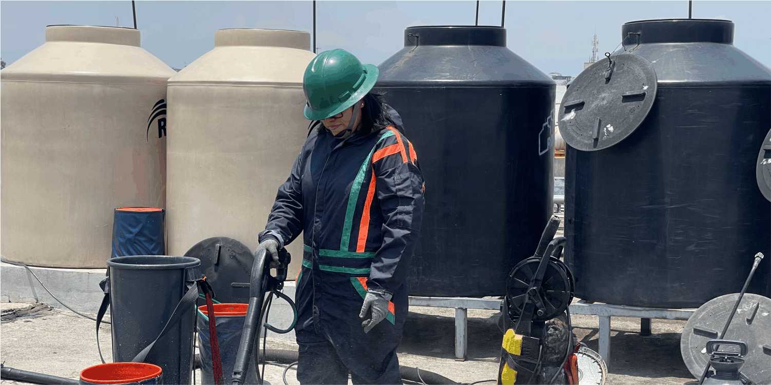 Operador enjuagando una tapa durante el lavado de tinacos en Coacalco