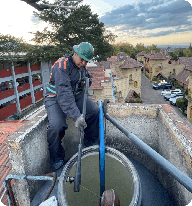 Operador realiza un enjuague durante el lavado de tinacos en Nicolás Romero