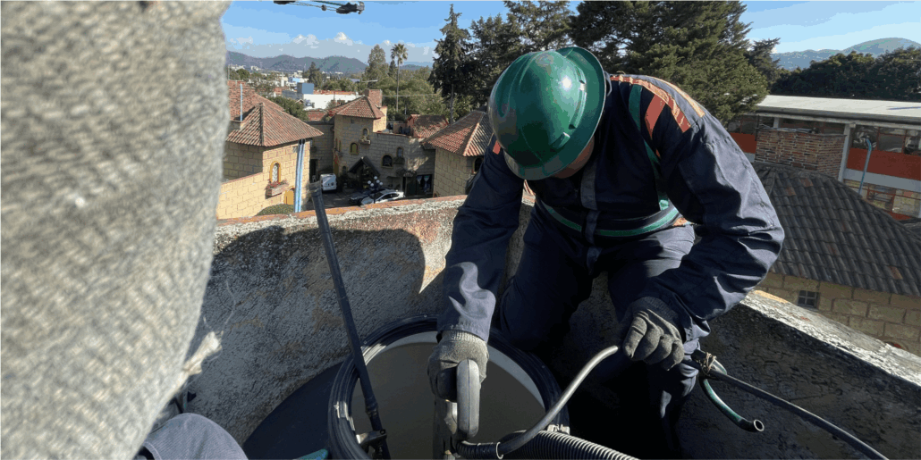 Operador realiza enjuague durante la limpieza de tinacos en Melchor Ocampo