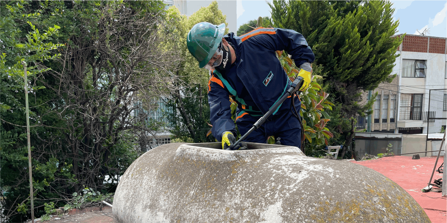 Operador realiza un enjuague a tinaco de asbesto durante el lavado de tinacos en Zumpango