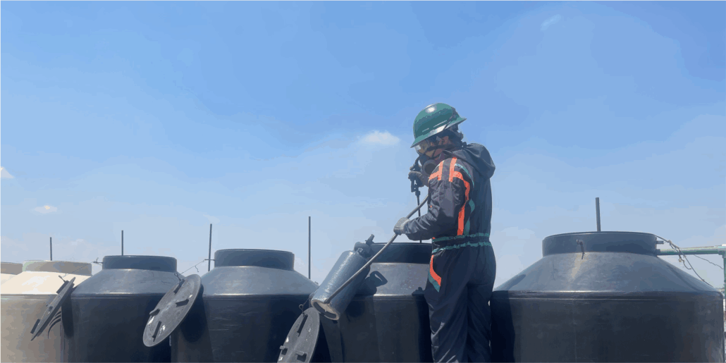Operador realizando una desinfección durante la limpieza de tinacos en Chimalhuacán