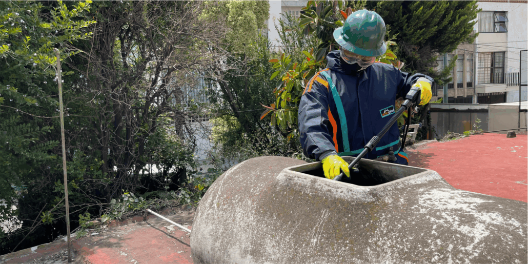 Operador realiza enjuague durante la limpieza de tinacos de asbesto en Nezahualcóyotl