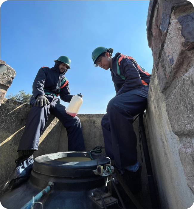Operadores aplicando desinfectante durante el lavado de cisternas y tinacos en Huixquilucan