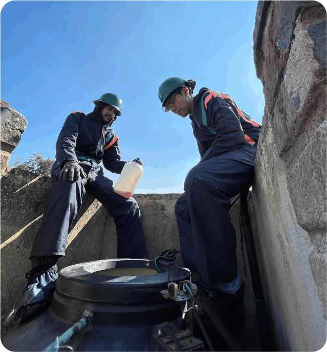 Operadores aplicando desinfectante durante el lavado de tinacos en Huixquilucan