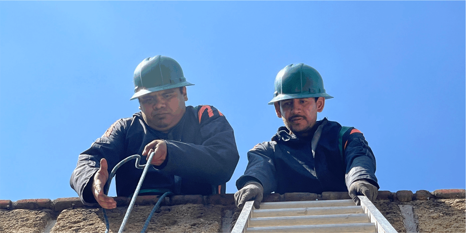 Operadores subiendo equipos para el lavado de tinacos en Tláhuac