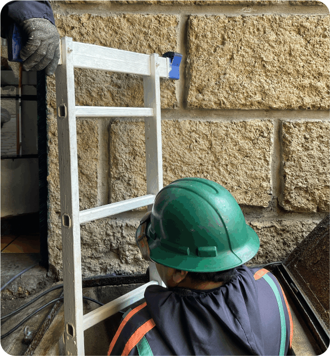Técnico descendiendo por escalera para realizar el lavado de cisternas en Atizapán de Zaragoza