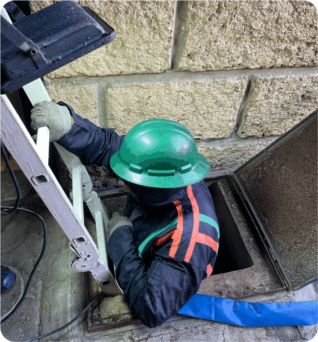 Técnico ingresando a cisterna para realizar una limpieza de cisternas en Lerma