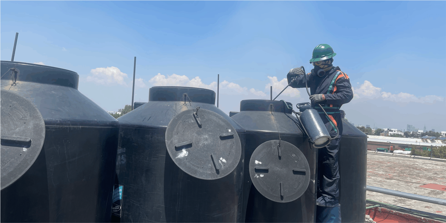 Técnico realiza una desinfección durante el lavado de tinacos en Nezahualcóyotl