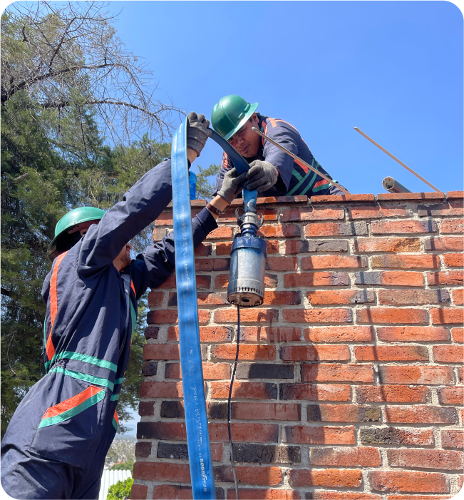 Técnicos con la herramienta de extracción para realizar una limpieza de cisternas y tinacos en Huixquilucan