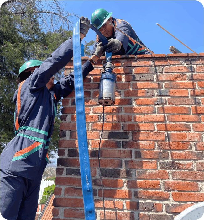 Técnicos con la herramienta de extracción para realizar una limpieza de tinacos en Huixquilucan