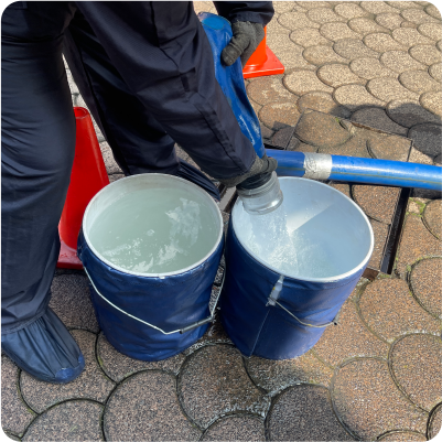 Drenado de agua sucia de tinaco en cubetas durante el lavado de tinacos en CDMX y EDOMEX