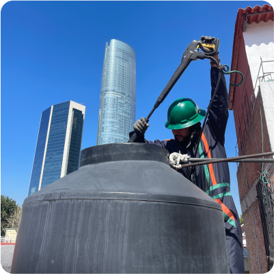 Operador enjuaga tinaco de plástico durante el lavado de tinacos en CDMX y EDOMEX