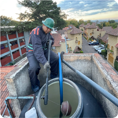 Técnico enjuaga un tinaco sin ingresar en el durante el lavado de tinacos en CDMX y EDOMEX