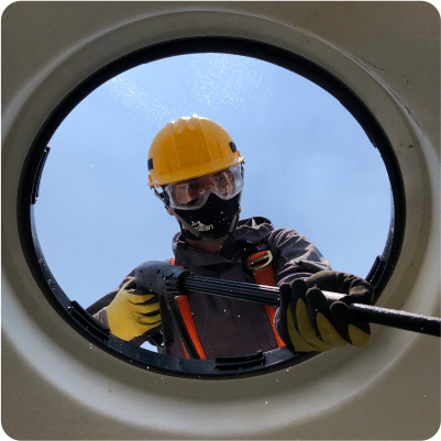 Técnico realiza enjuague desde el exterior de un tinaco durante la limpieza de tinacos en CDMX y EDOMEX