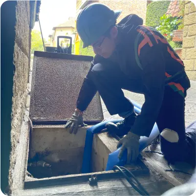 Operador extrae sedimentos de cisterna de concreto durante el lavado de cisternas en CDMX y EDOMEX