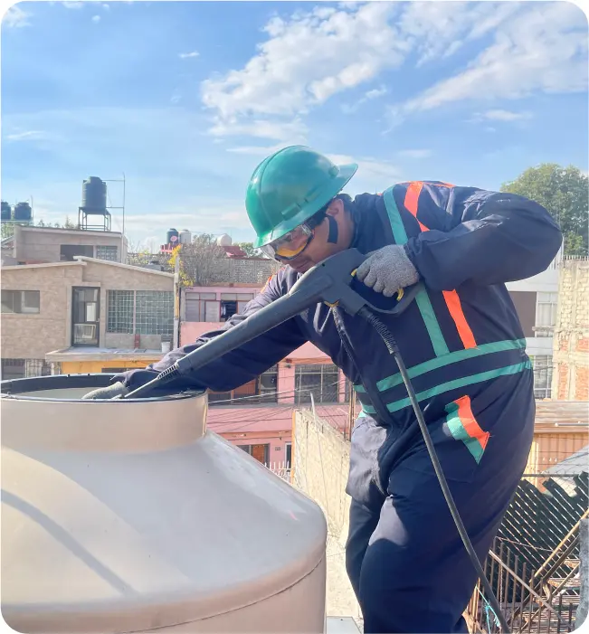 Operador enjuaga tinacos durante la limpieza de tinacos y cisternas en CDMX y EDOMEX