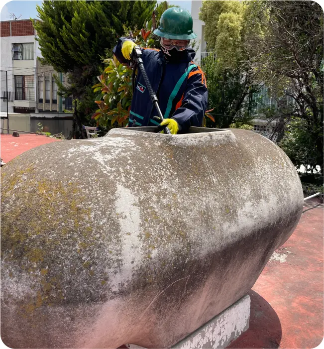 Técnico realiza una desinfección a tinaco de asbesto durante la limpieza de tinacos en Milpa Alta