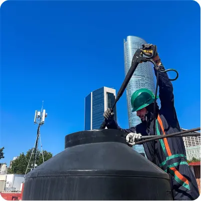 Técnico realiza enjuague desde el exterior de un tinaco durante la limpieza de tinacos en CDMX y EDOMEX